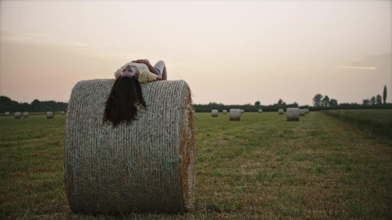 一个年轻的女人躺在一捆干草上视频素材