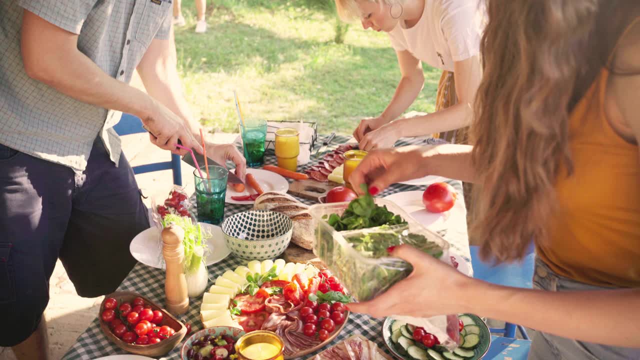 夏天在花园里吃早午餐，兴高采烈的朋友们在准备食物视频下载