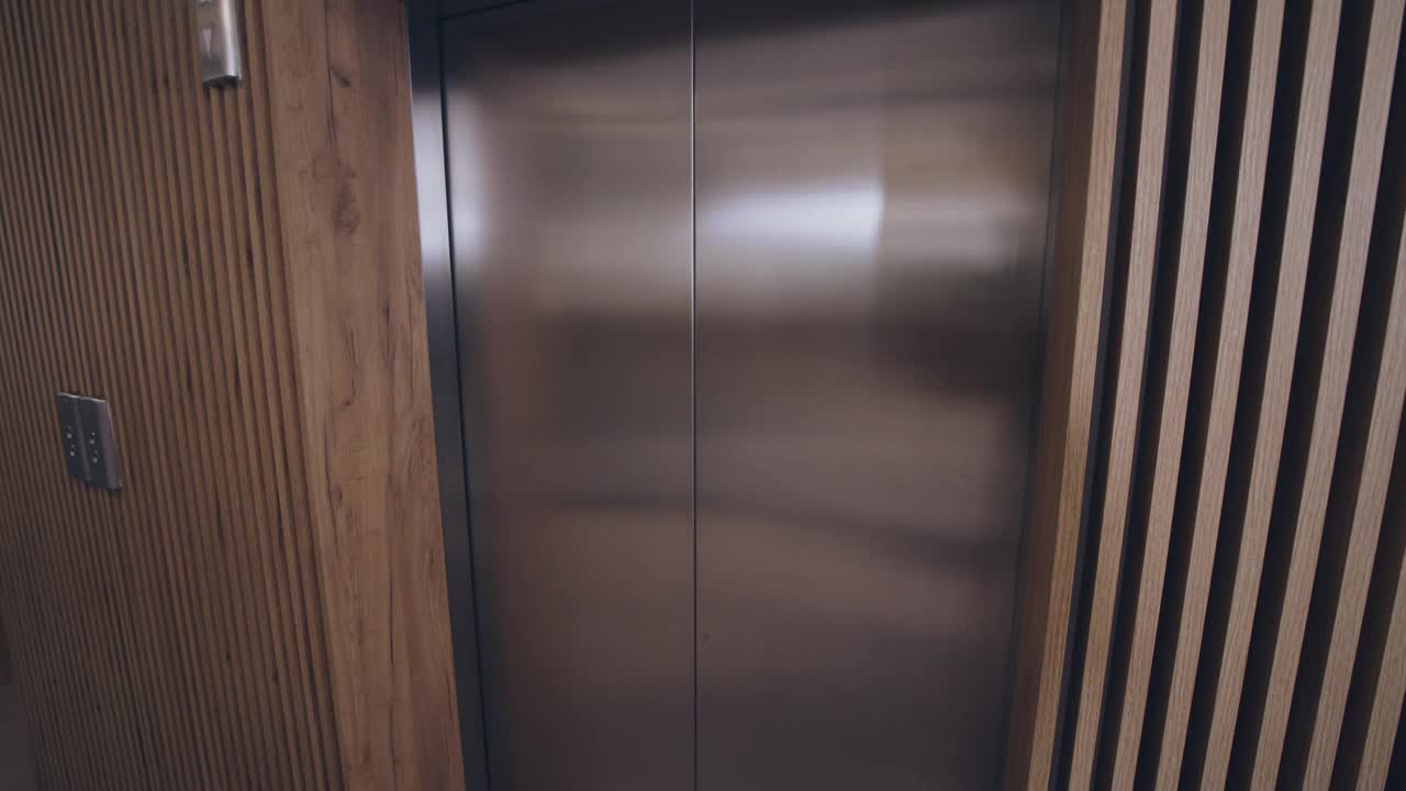 年轻的女商人走出电梯，进入办公室大厅视频下载
