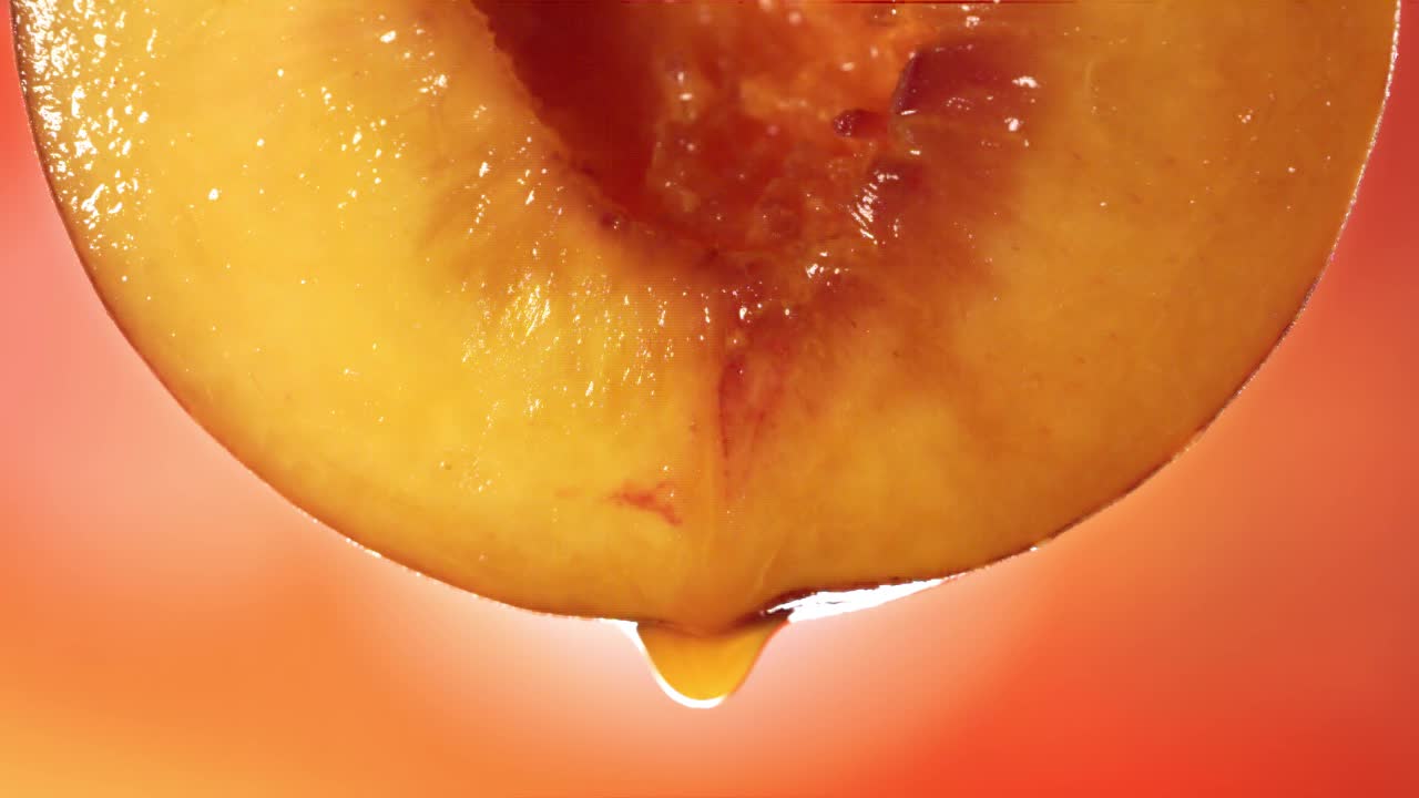 从半桃子流出的桃子汁的慢动作微距镜头视频素材