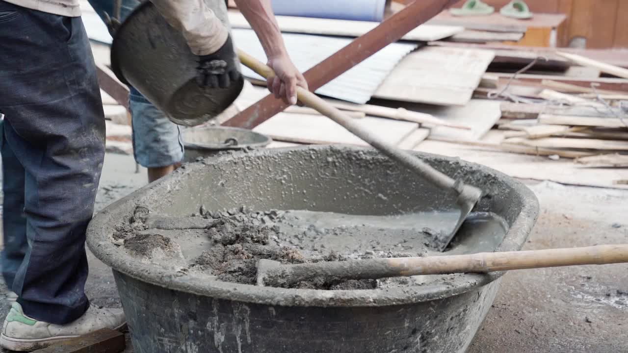 工人在建筑工地搅拌和浇筑水泥。视频素材