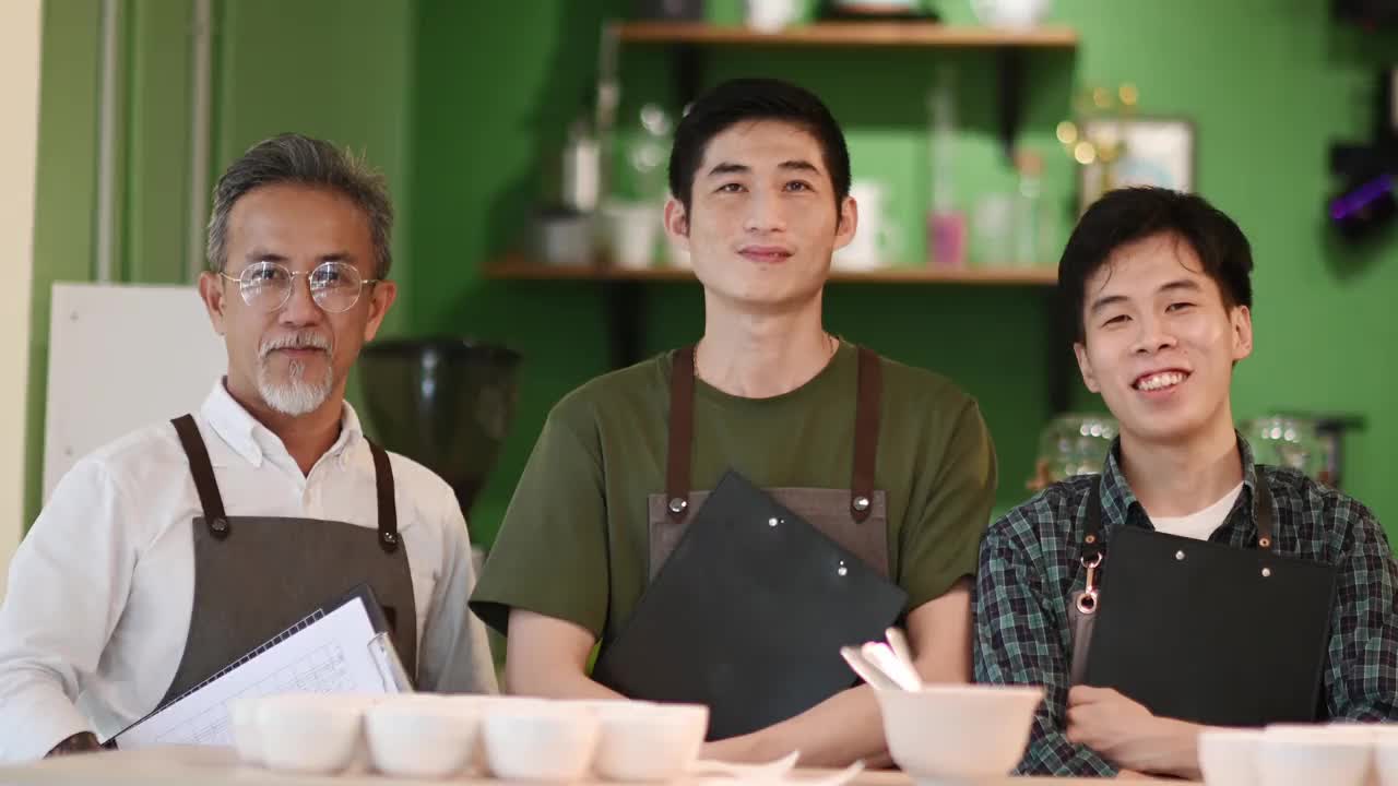肖像亚洲华裔高级男子咖啡师鉴赏家和他的同事在咖啡泡制前看着镜头微笑视频素材