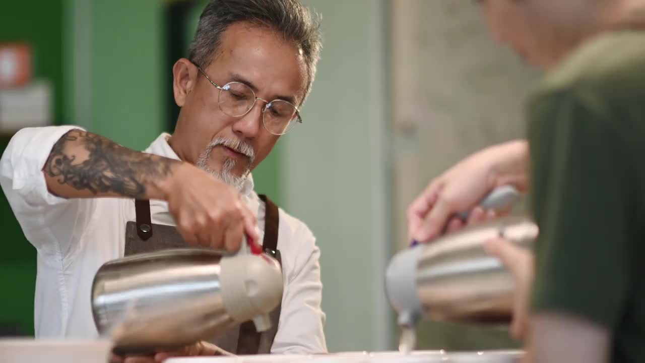 专业亚洲华人高级男咖啡师品级员将热水倒入陶瓷咖啡杯中，准备拔杯咖啡品质测试视频素材