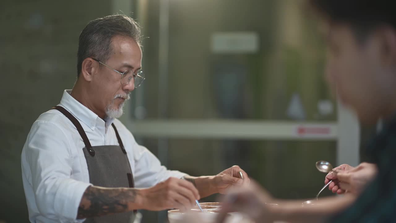亚洲华人高级男子咖啡师鉴定家舀咖啡研磨清洁咖啡品酒范围视频素材