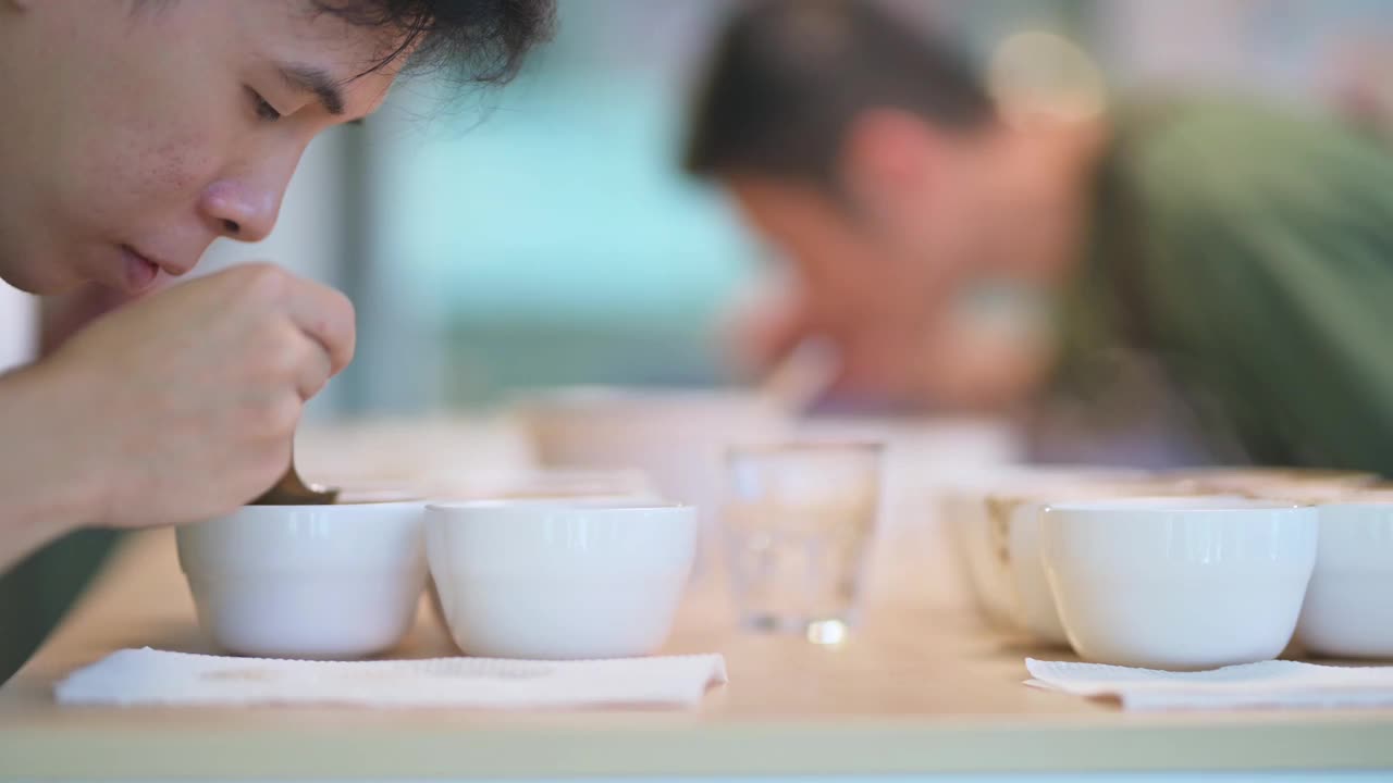 专业的亚洲华人咖啡师表演咖啡杯品尝咖啡杯用勺子视频素材