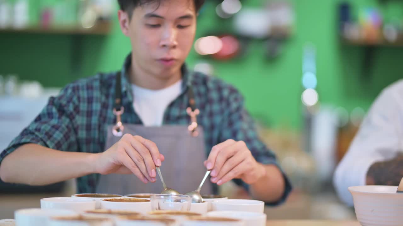 亚洲的中国咖啡师鉴赏家舀咖啡研磨清洁，为咖啡杯品尝范围视频素材