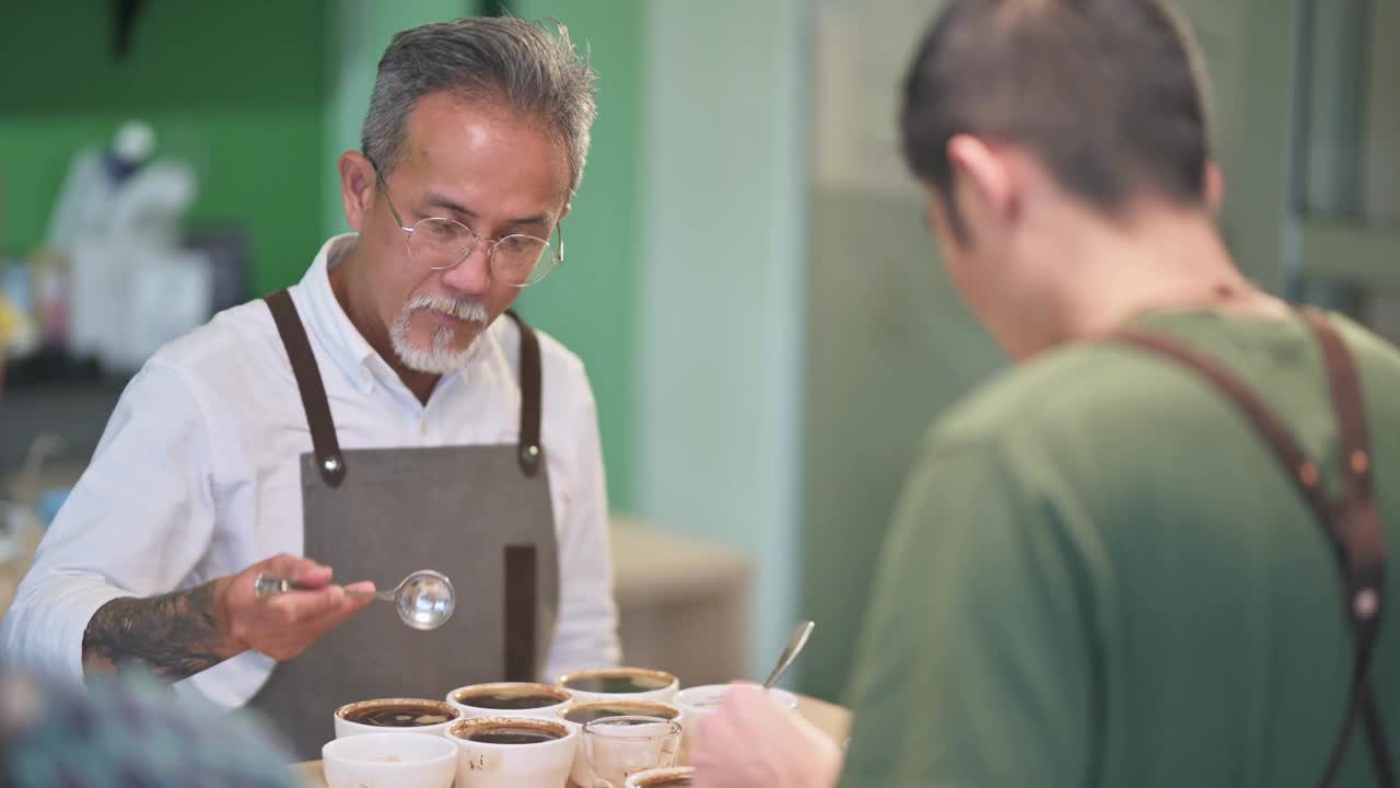 亚洲华人高级男子咖啡师鉴定家舀咖啡研磨清洁咖啡品酒范围视频素材