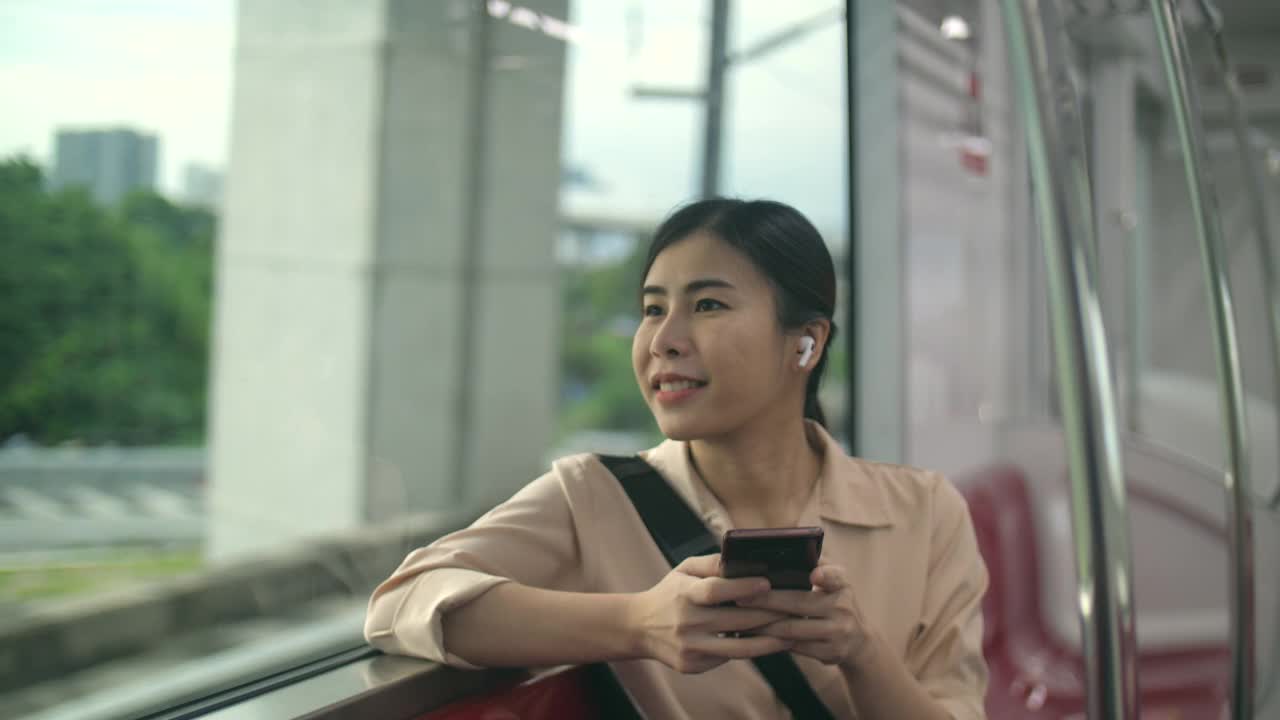 年轻漂亮的女人戴着无线耳机在火车上工作视频素材