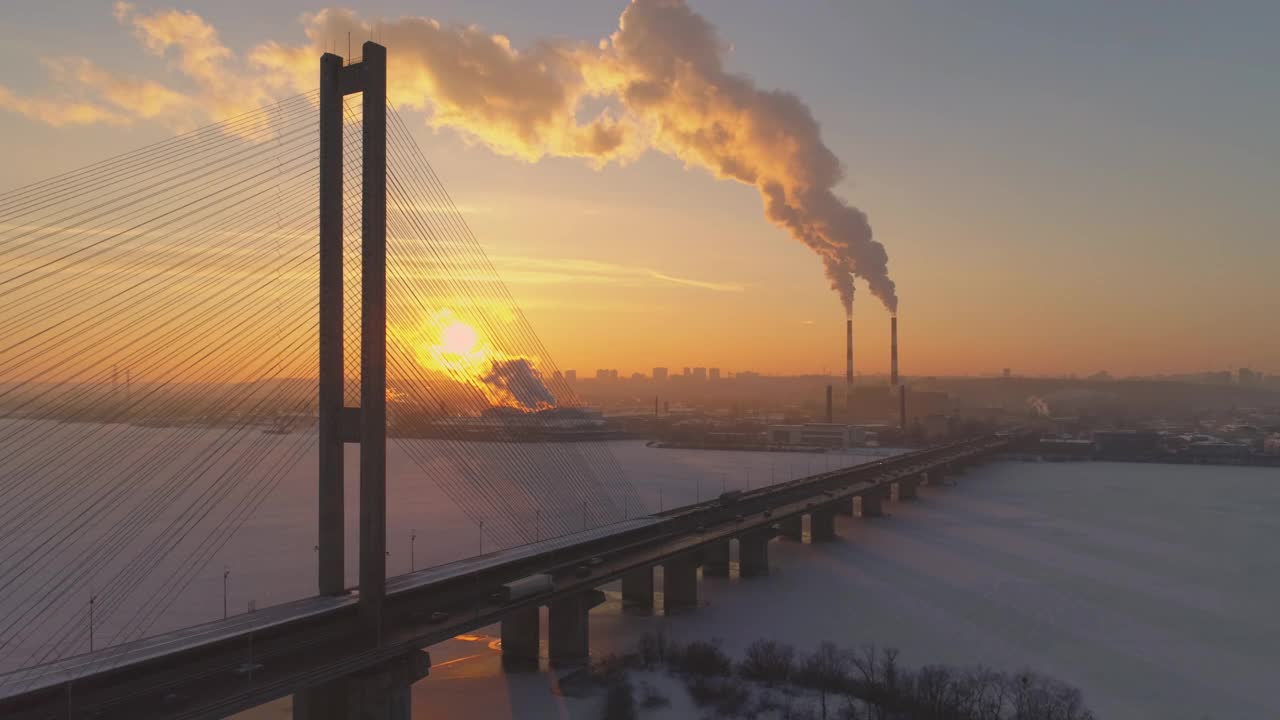 在结冰的湖泊或河流上，烟筒和高速公路桥梁向后架空视频素材