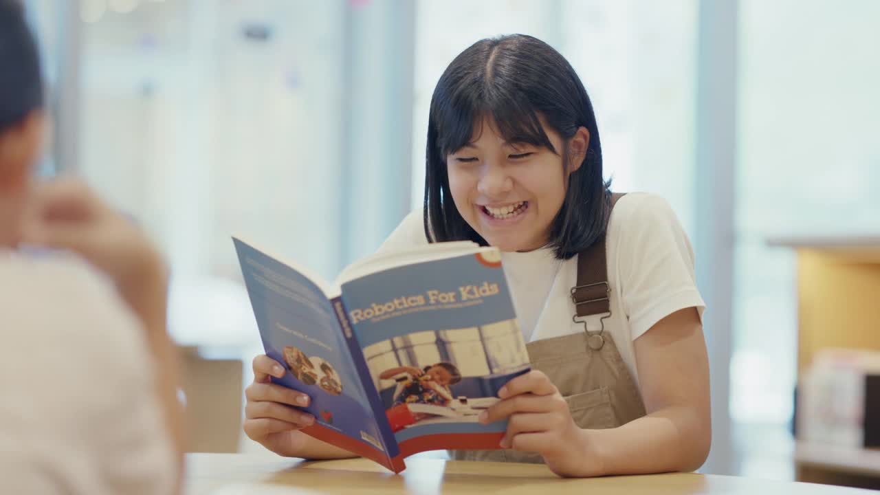 MS青春期前的女孩在图书馆阅读视频素材