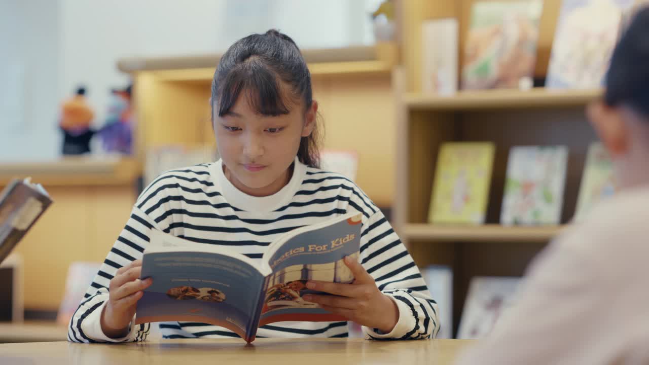 MS青春期前的女孩在图书馆阅读视频素材