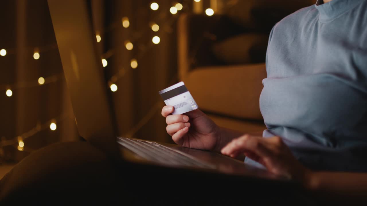 亚洲女人网上购物在她的笔记本电脑在圣诞节在家，手持拍摄视频素材