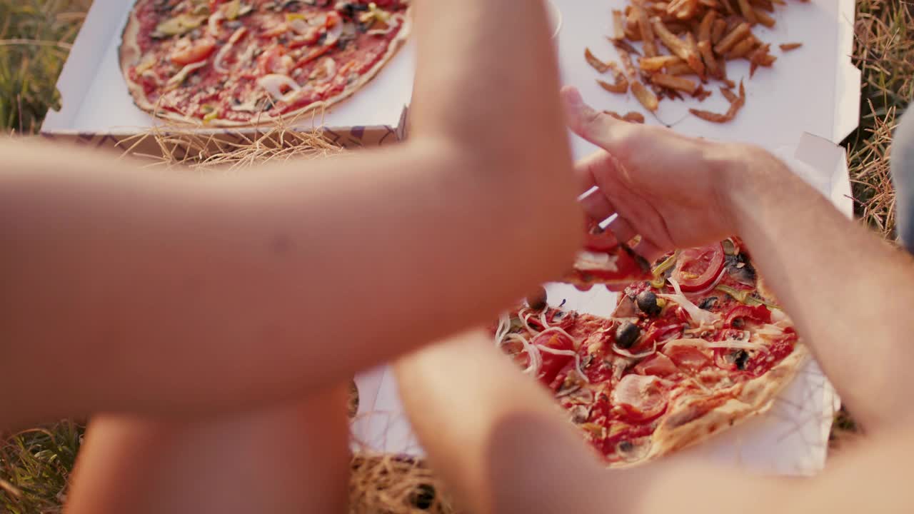 一群朋友在海滩上吃素食披萨和薯条视频下载