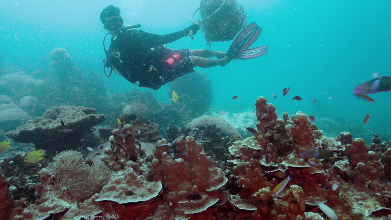环境清理志愿者水肺潜水员在水下移除网视频素材