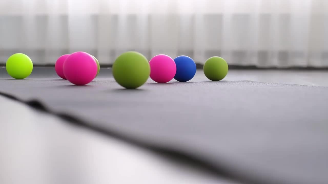 多色球在瑜伽垫上，一个肌筋膜释放球在垫子上滚动视频下载