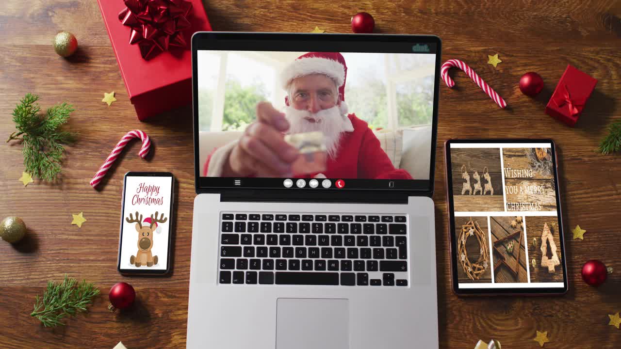 快乐的白人年长圣诞老人在笔记本电脑上视频通话，智能手机，平板电脑圣诞装饰视频下载