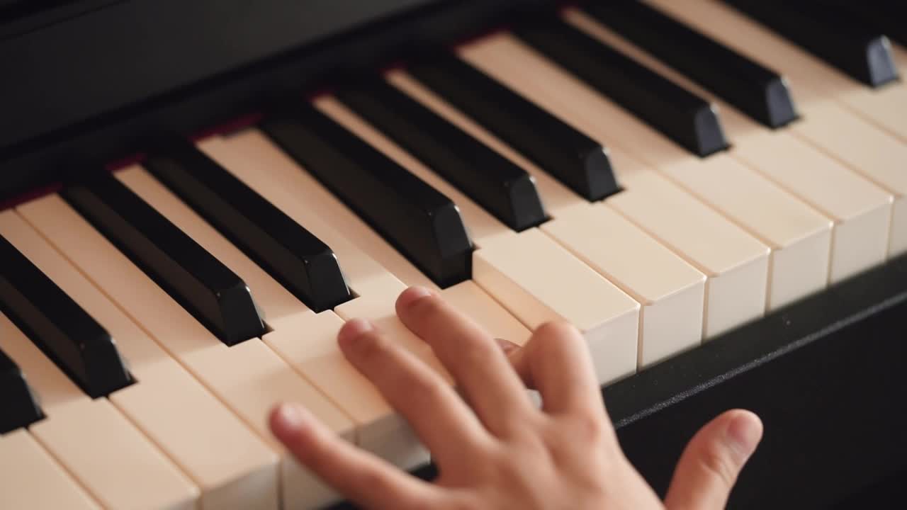 一只手在用慢动作弹钢琴的特写镜头。视频素材