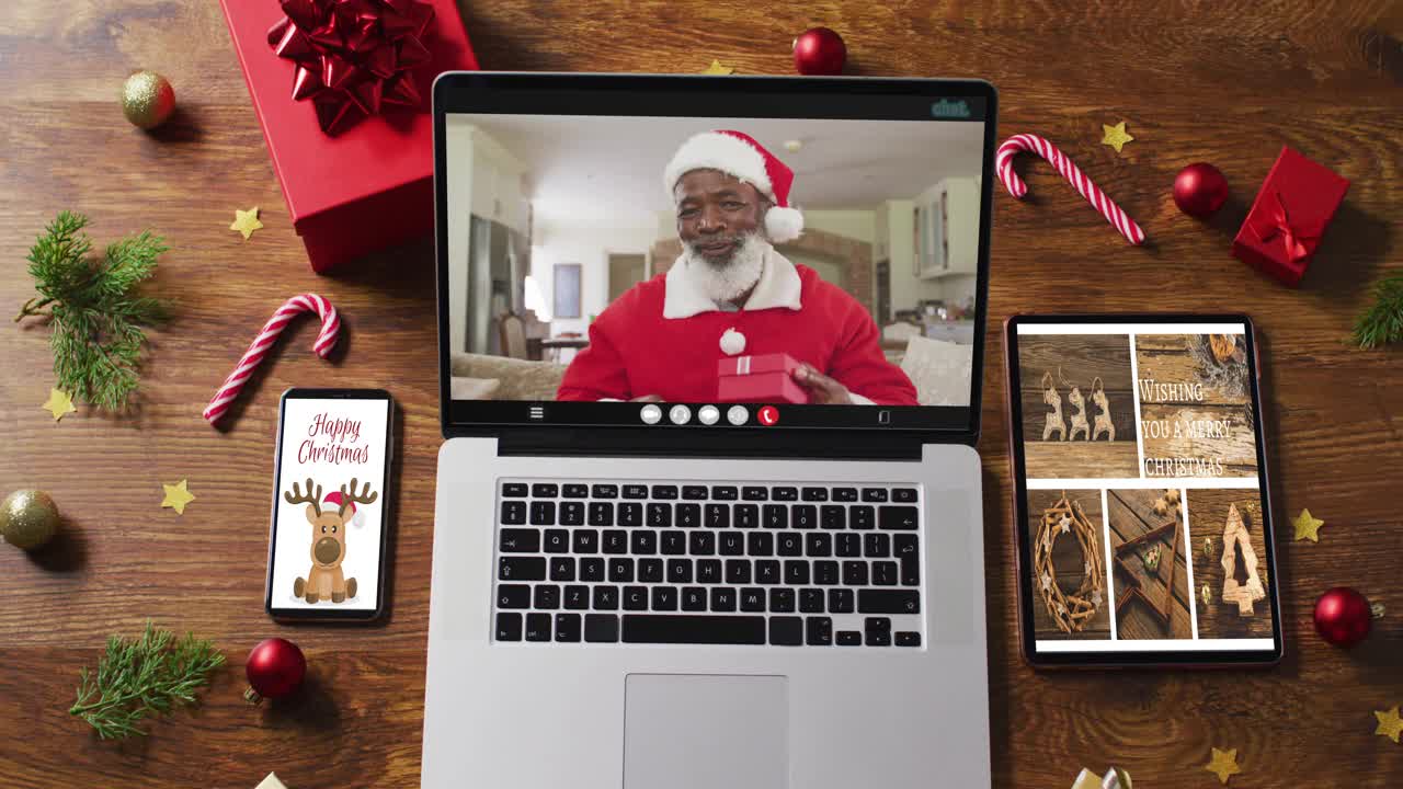 高级非洲裔美国人在圣诞老人服装视频通话，智能手机，平板电脑和装饰视频下载