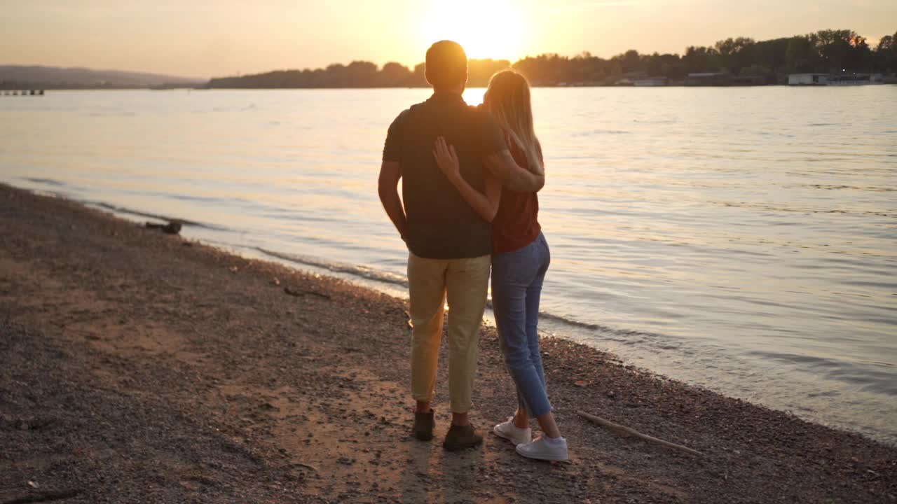 一对浪漫的情侣，欣赏着河上壮丽的日落，享受着它的每一刻视频下载
