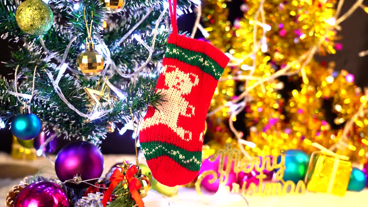 圣诞老人的红色长筒袜挂着，圣诞装饰以闪烁的彩灯为背景视频下载