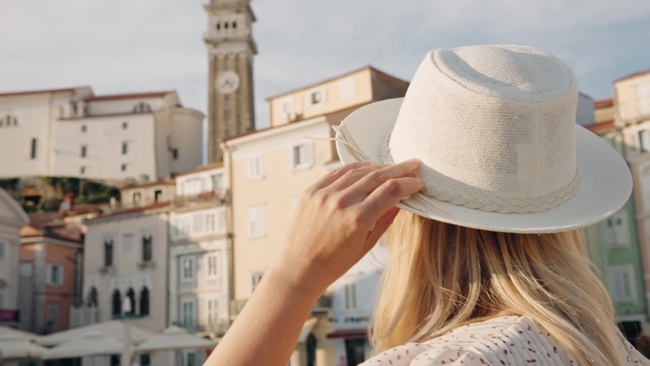 一名妇女戴着帽子走在著名的塔尔蒂尼耶夫广场上视频下载