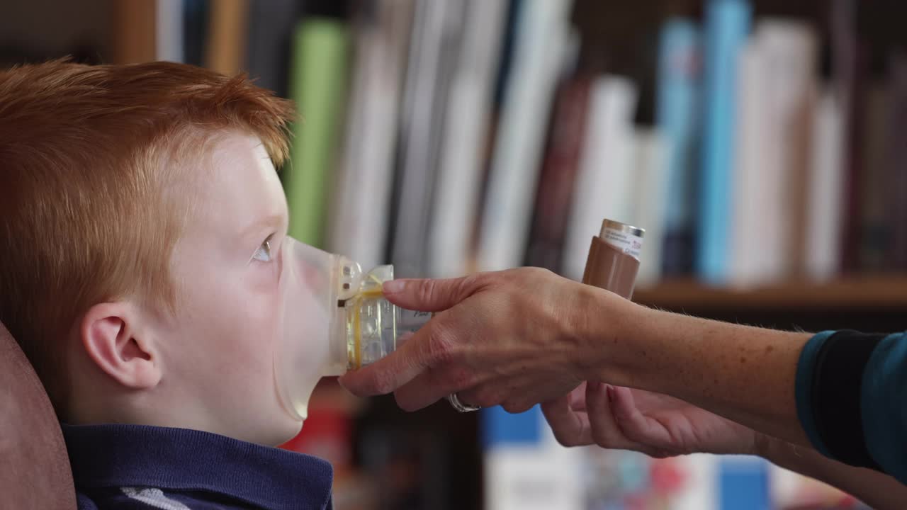 红发小男孩接受母亲的呼吸性哮喘治疗视频下载
