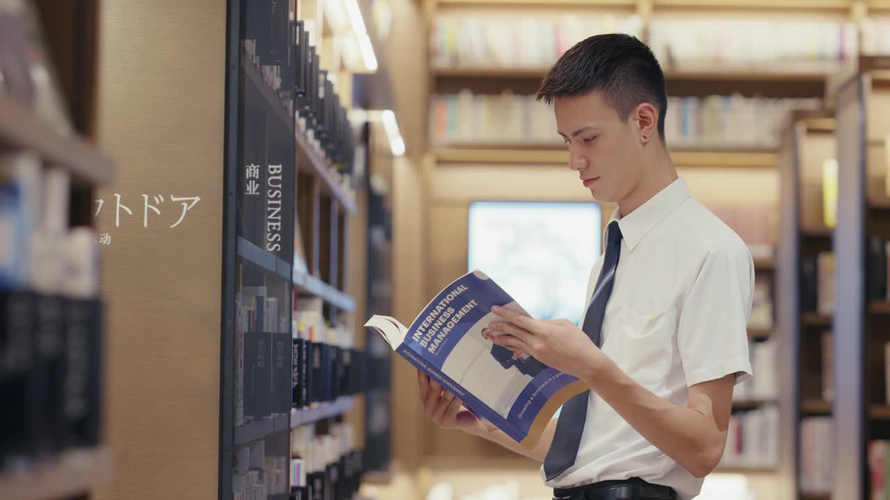 MS年轻的男学生正在阅读一本商业教科书视频下载