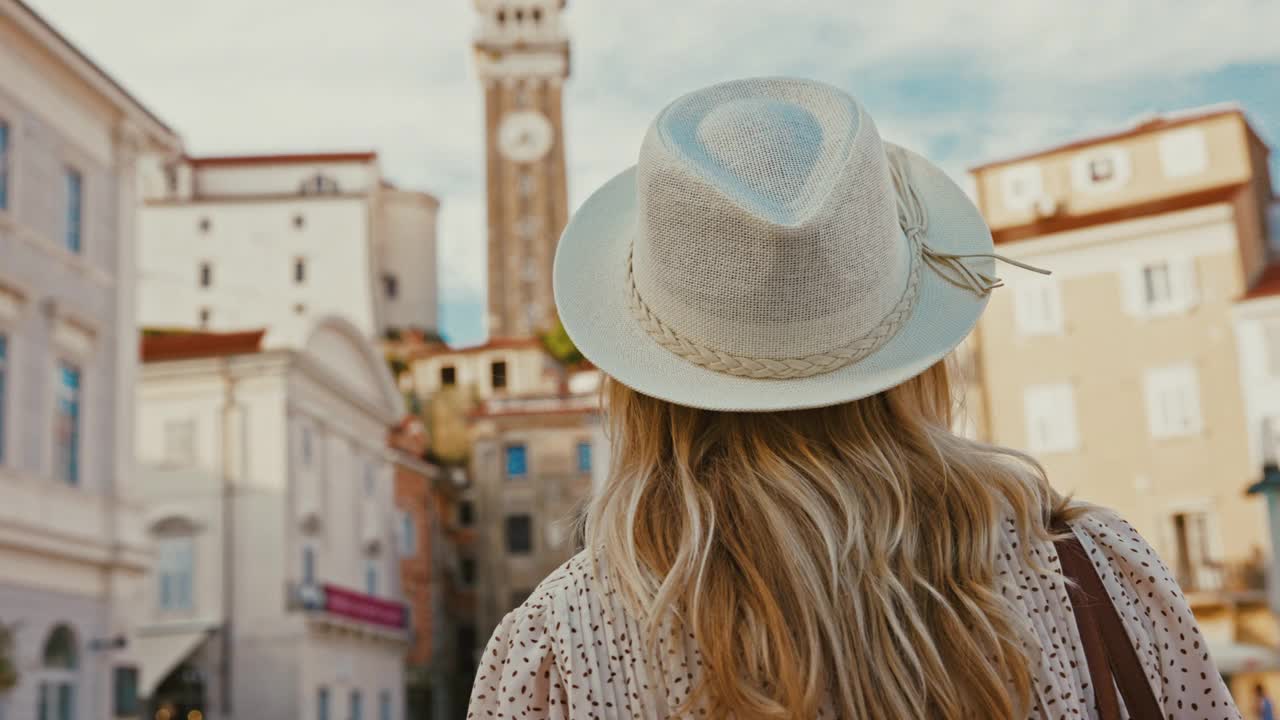 一位戴着帽子的女士在塔尔蒂尼耶夫广场上欣赏着教堂塔楼的景色视频下载