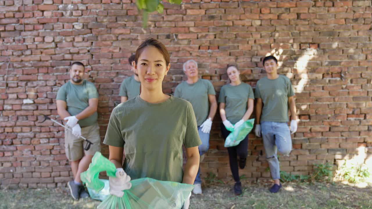 环境清理后，志愿者拿着垃圾袋站在志愿者队伍面前视频下载
