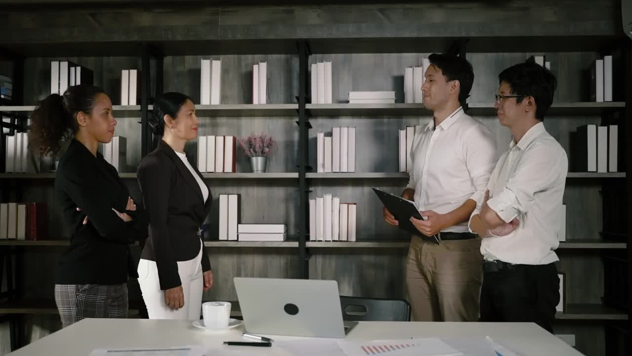 一位亚洲女商人和一位白人商人正在握手，准备达成一项商业协议。视频素材