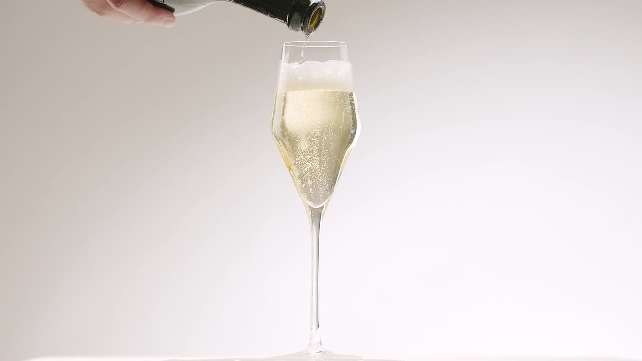 将香槟酒倒入白底的起泡杯中视频素材