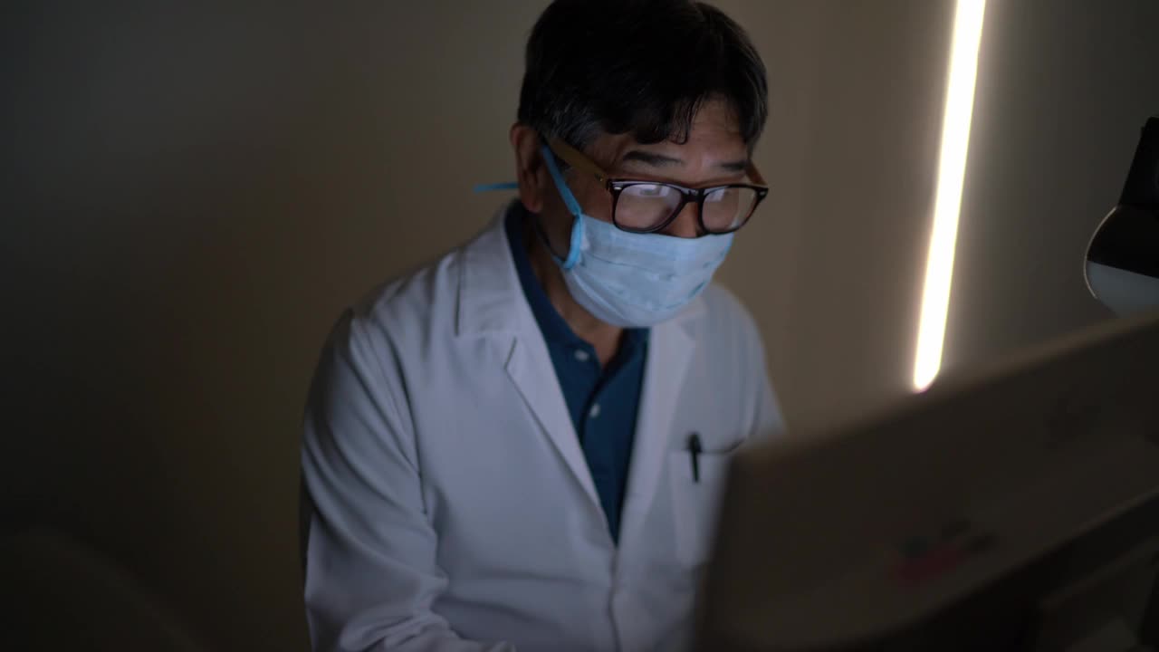 医生戴着防护口罩，在监视器上分析检查结果视频下载