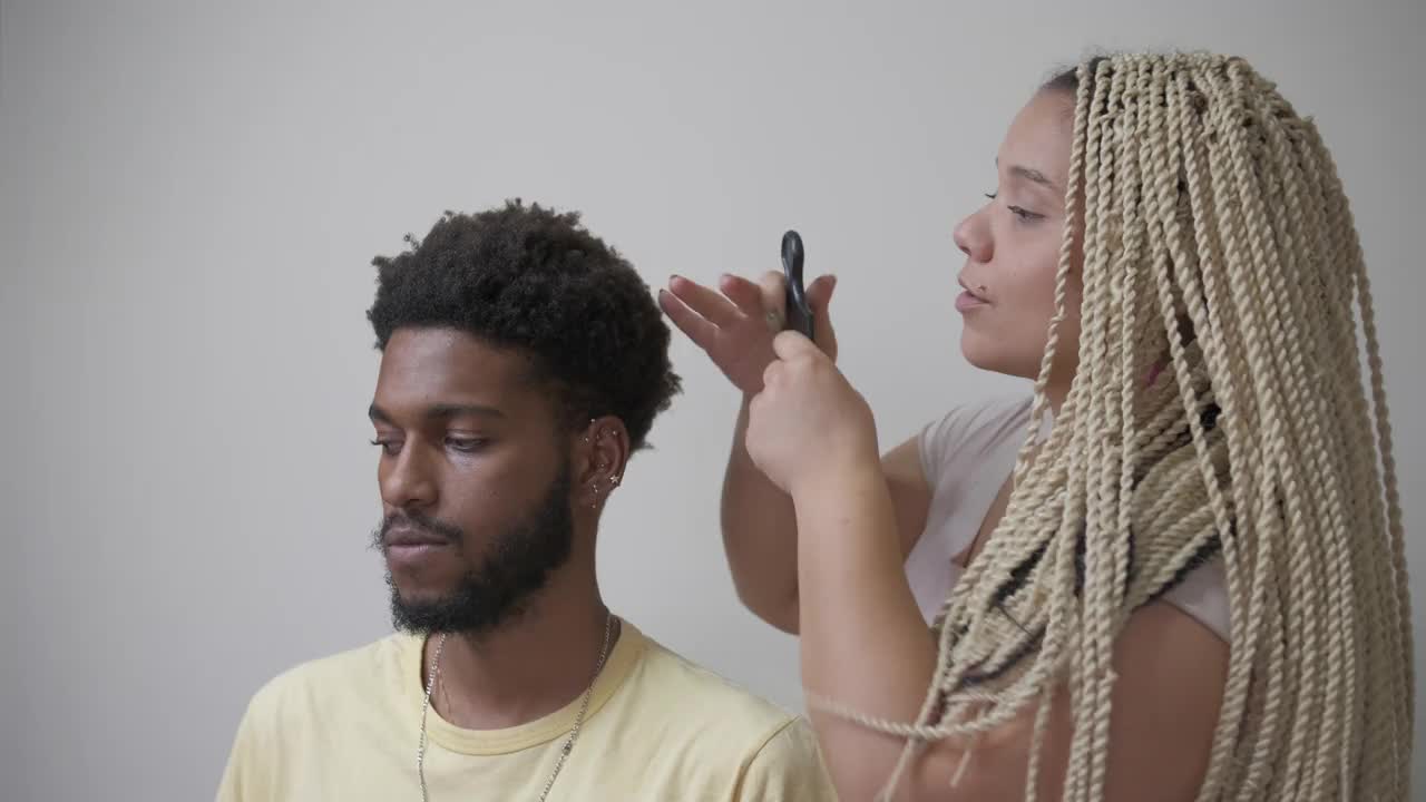 女人用非洲式梳子梳男人的头发视频素材