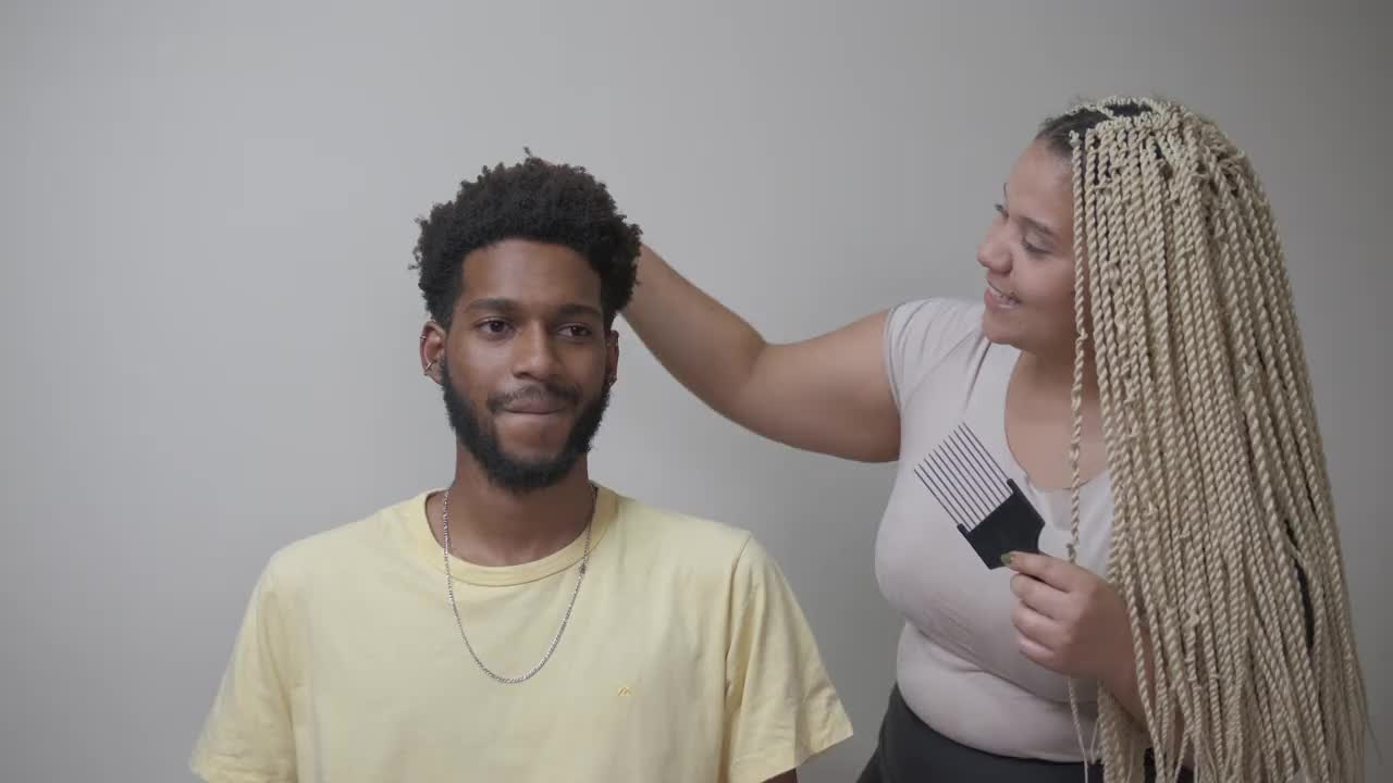 女人用梳非洲式发型的梳子照顾男人的头发视频下载