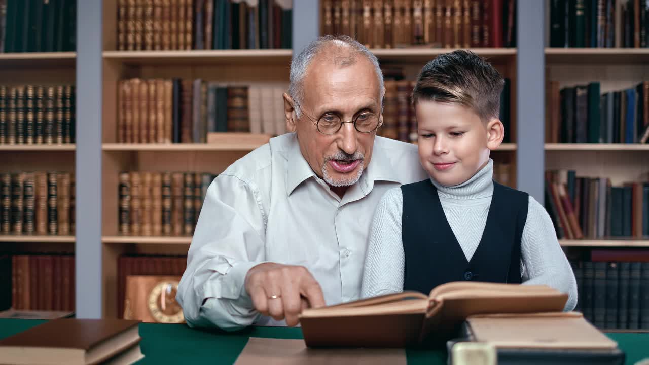 男孩的孙子和老教授的爷爷谈论着科学探索，阅读着教科书视频下载