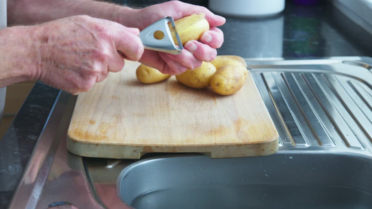 老男人在厨房里削土豆皮视频下载