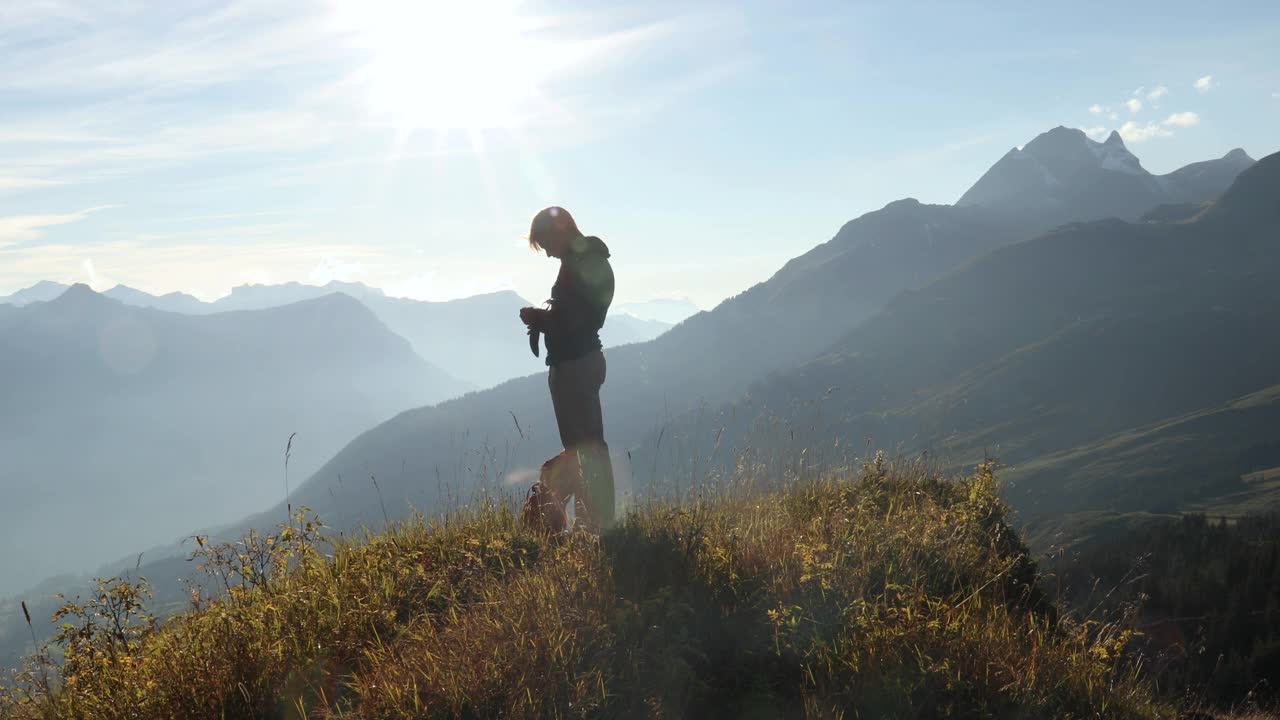 男性徒步旅行者在长满草的山顶上散步视频下载
