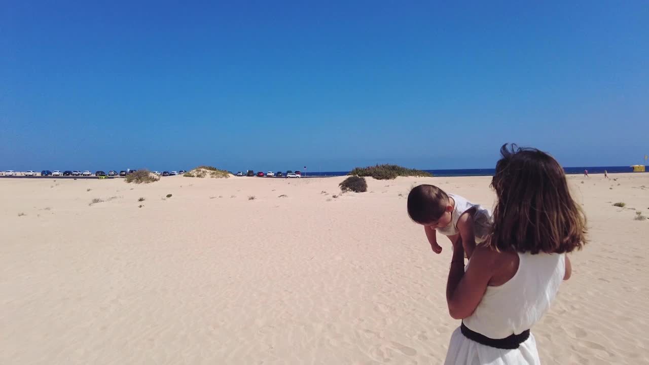 在加那利群岛富埃特文图拉科拉莱霍自然公园的沙丘上，年轻的母亲和她的儿子在度假。西班牙视频素材