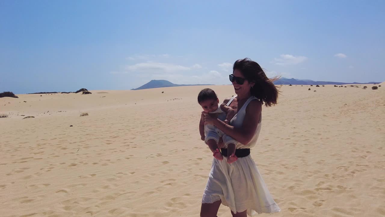 在加那利群岛富埃特文图拉科拉莱霍自然公园的沙丘上，年轻的母亲和她的儿子在度假。西班牙视频素材