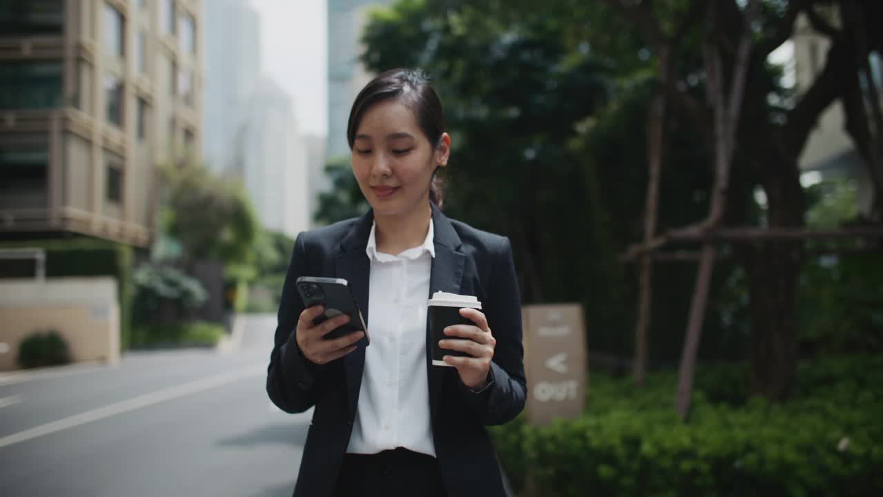 亚洲女商人正在用智能手机和朋友在线聊天视频素材