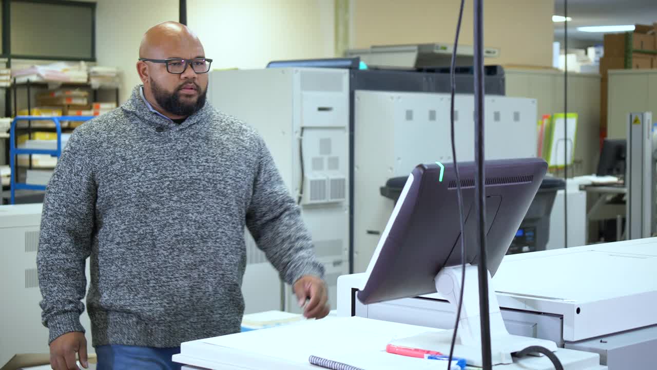 多种族的人在印刷厂工作，在电脑上视频素材