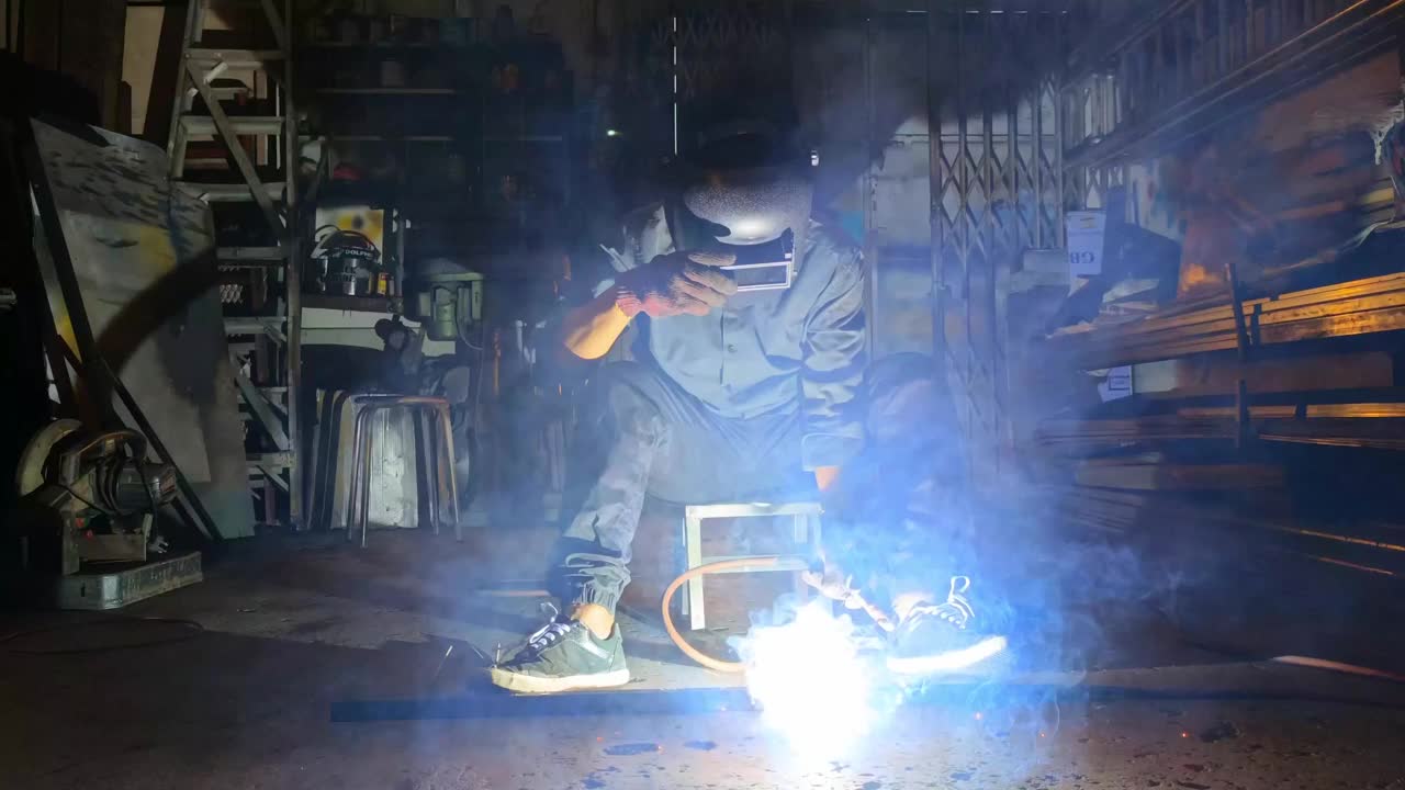 慢动作亚洲马来焊工在车间焊接工作，焊枪修理视频素材