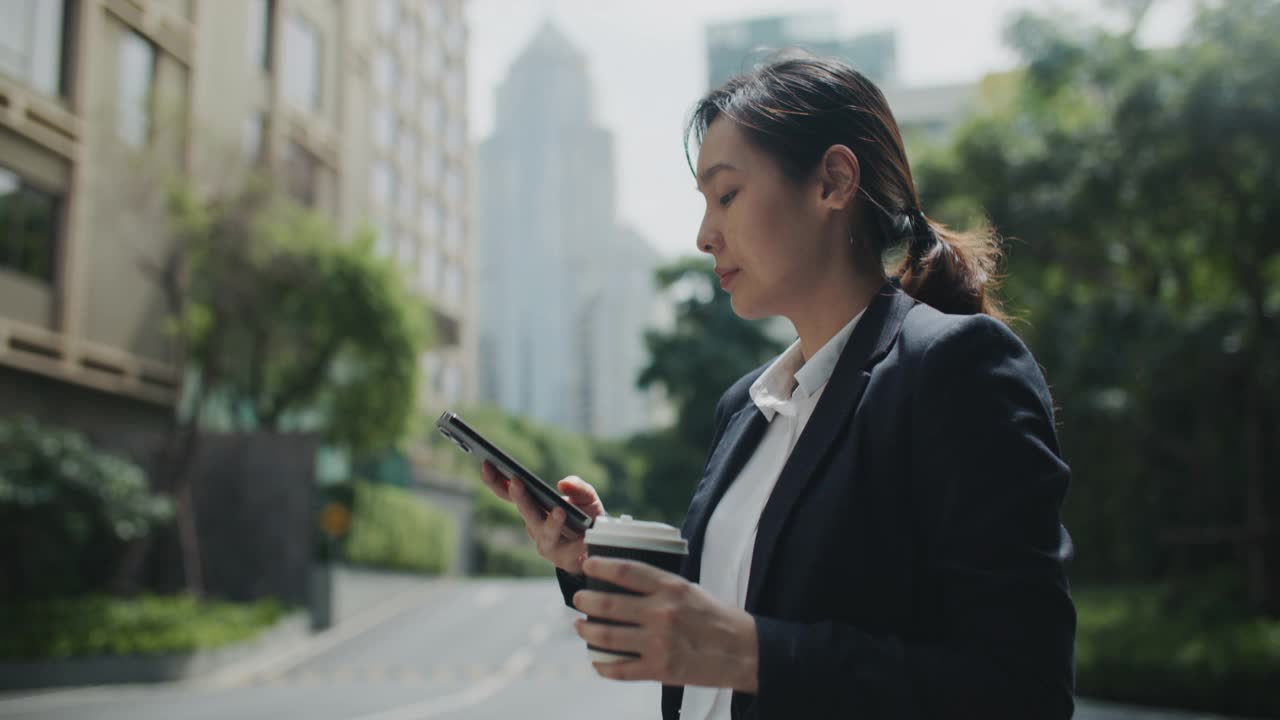 亚洲女商人在城市使用手机视频素材