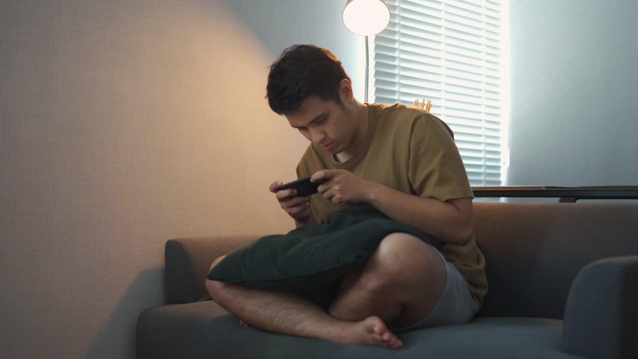 亚洲男人在玩手机游戏视频素材