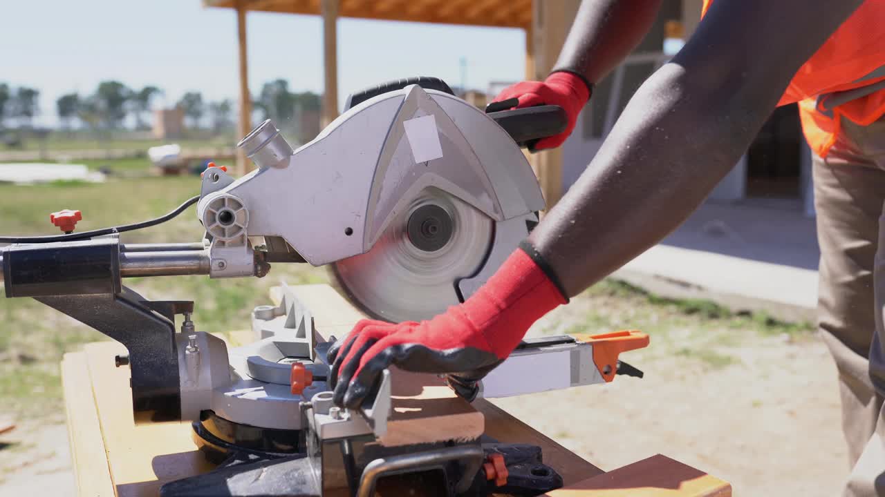 非裔美国工人在建造木结构房屋时锯木板的细节视频下载