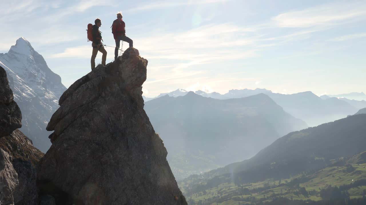 男性登山运动员登上岩石的顶峰视频下载