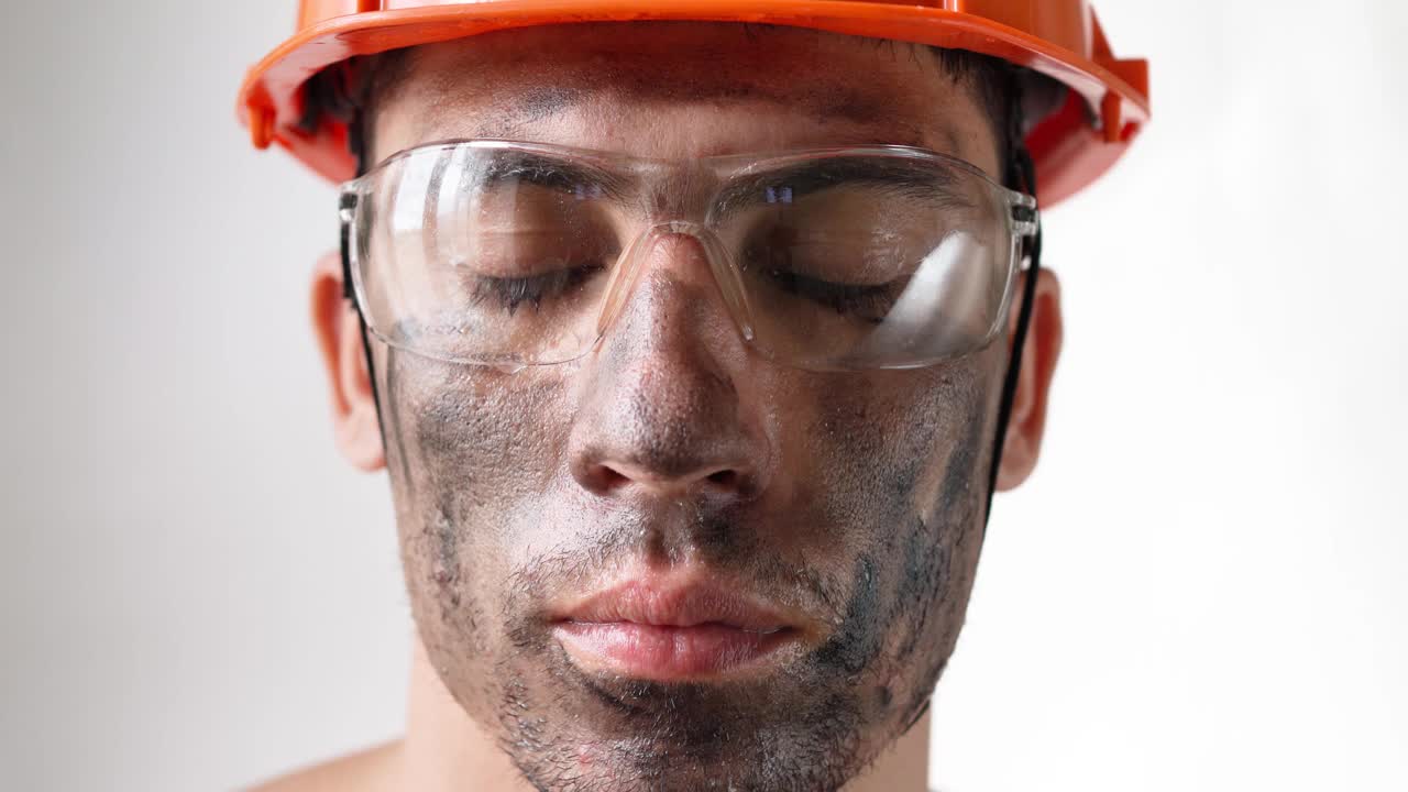 肖像肮脏疲倦的男建筑工人在工作头盔和眼镜看相机视频素材