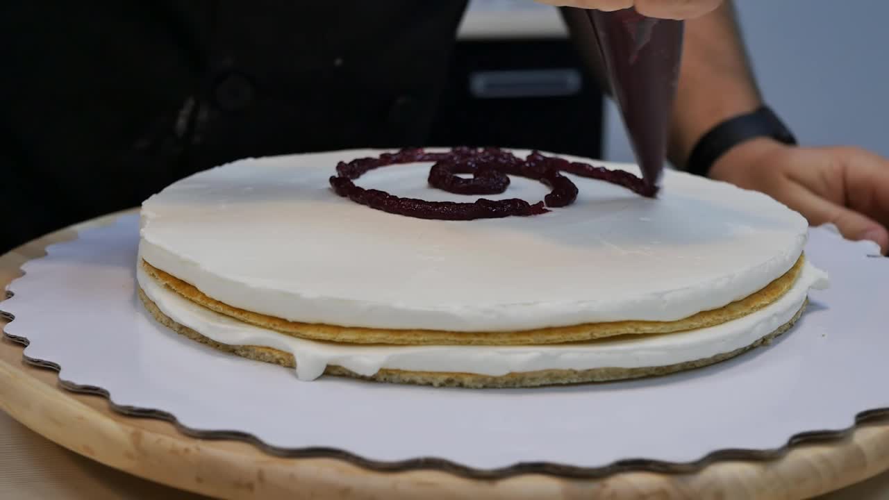 糕点师的手把果酱挤到带奶油的饼干上视频下载