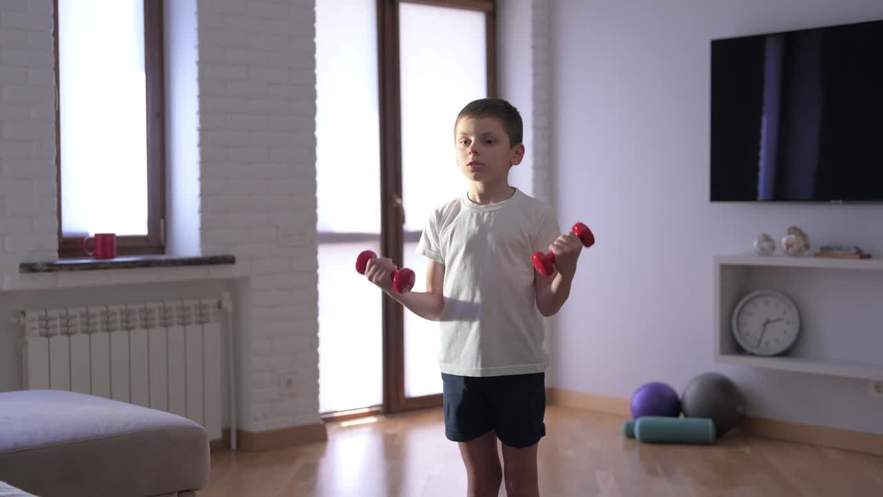 健康活跃的高加索小孩在室内举重哑铃，家庭运动训练，娱乐健身锻炼视频下载