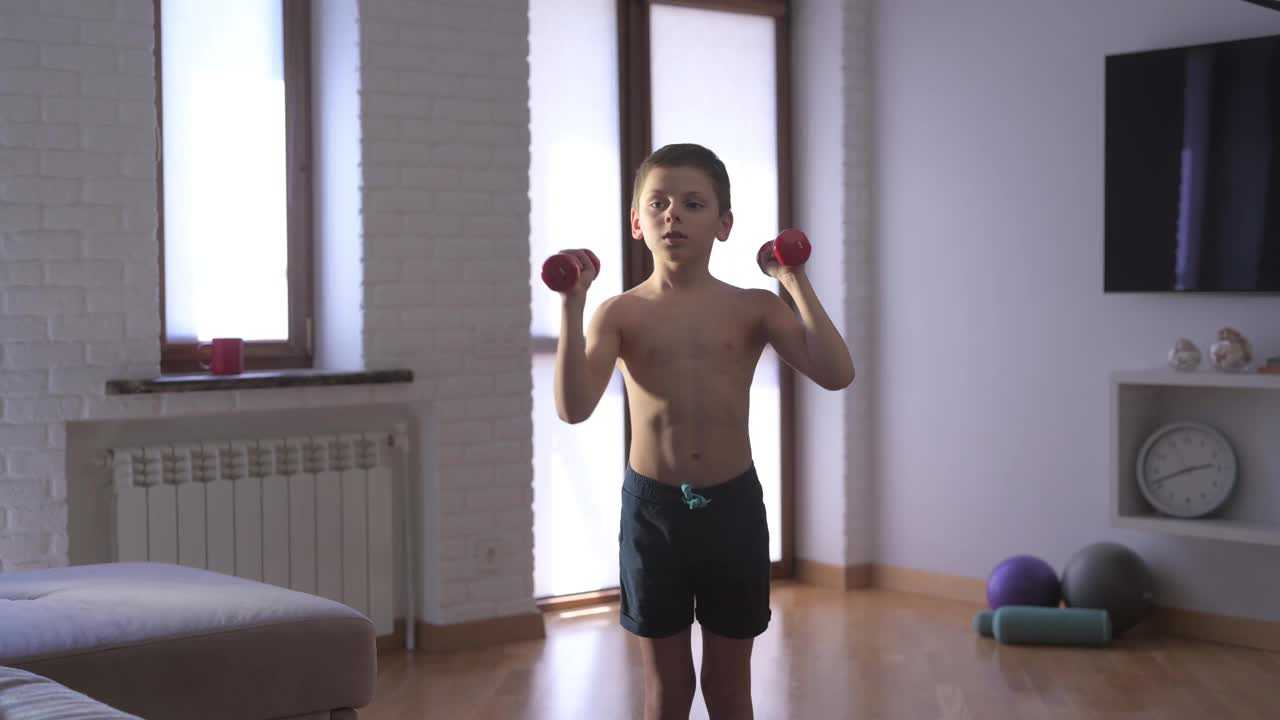 健康活泼的白人小孩，强壮的身体，举重，哑铃，在室内，家庭运动训练，娱乐健身锻炼视频下载